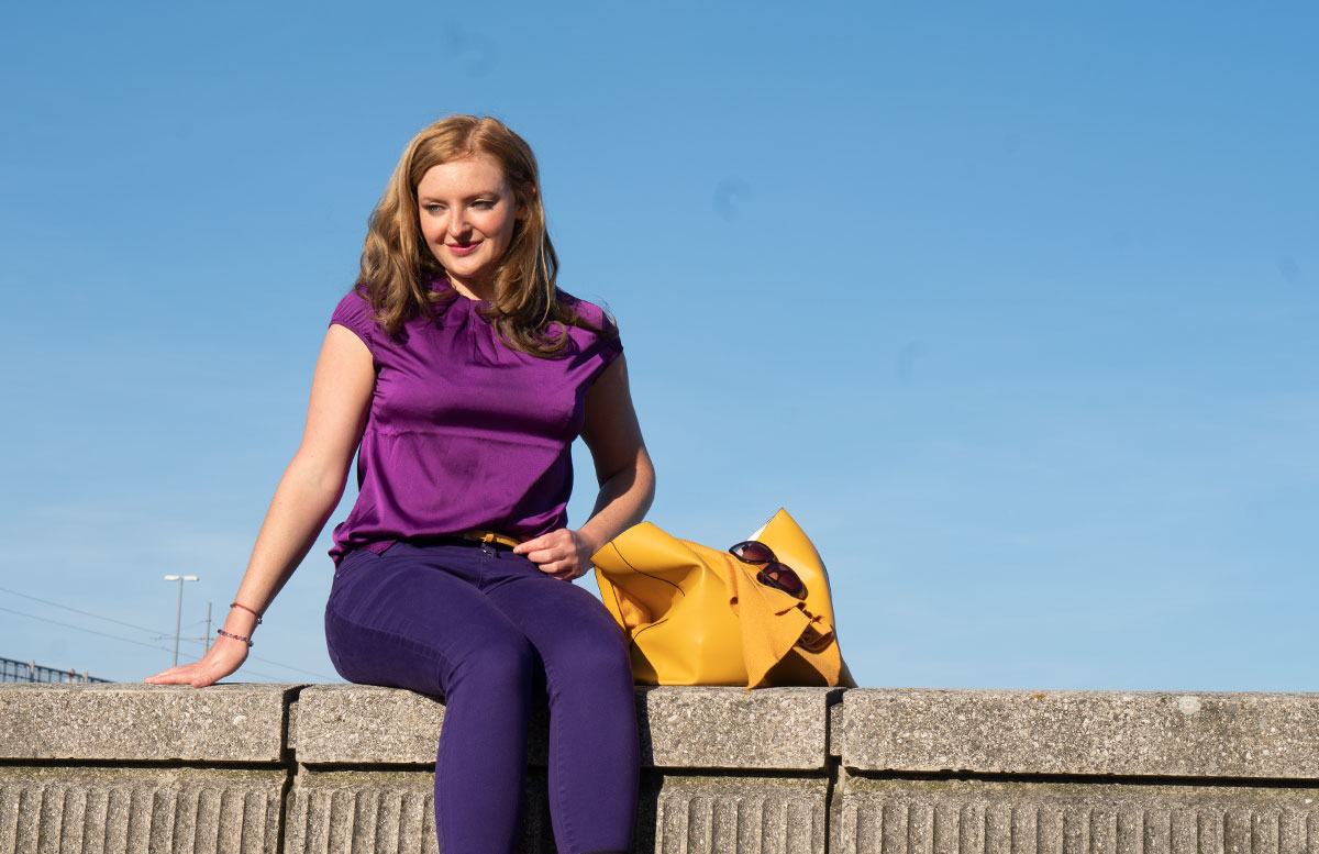 Meine-Trendfarben-2019-Outfit-Curry-und-Ultraviolett-rückenansicht-sizend-mit-seitlichem-blick