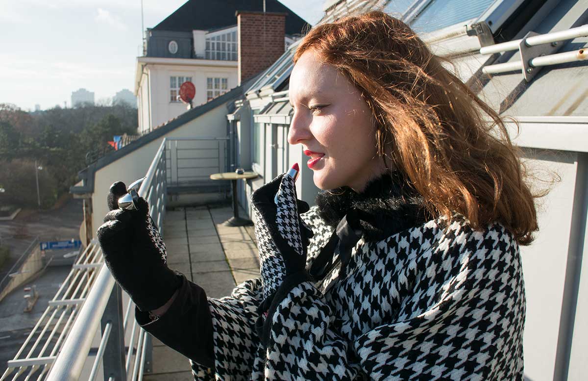 poncho-outfit-mit-hahnentrittmuster-lippenstift-bild