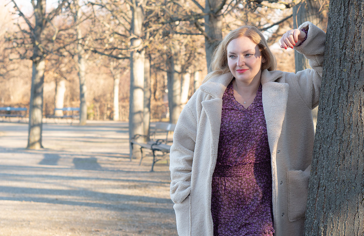 Winter-Trend-2022-Teddy-Mantel-und-Chelsea-Boots-baum-lehnend