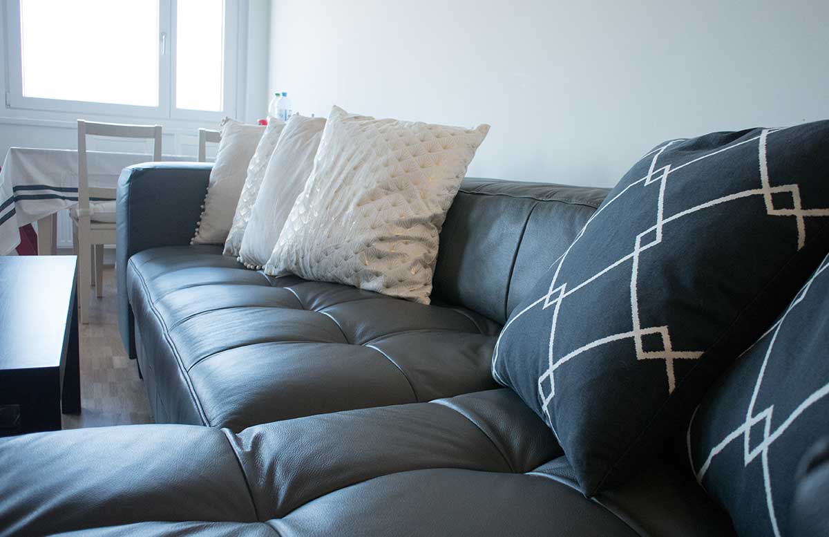 unsere-neue-Wohnung-Wohnzimmer-und-Küche-blaugraue-ledercouch-home24-detail
